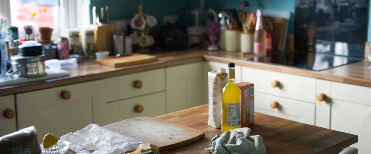 Country-style kitchen with solid oak worktops, cream Shaker cabinets and teal feature wall