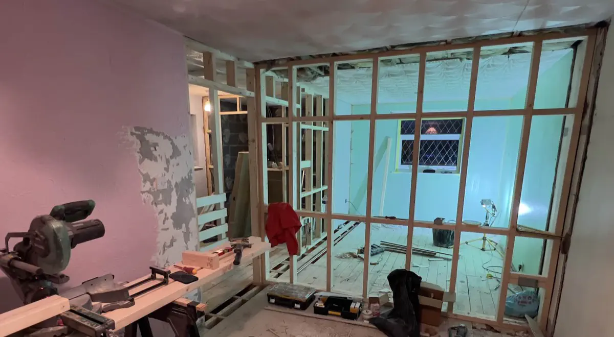 Rebuilding stud walls to create more space for the new bath installation