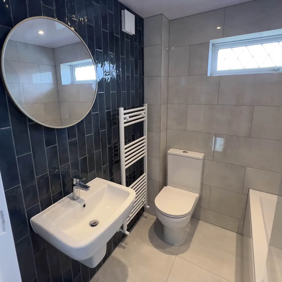 Finished bathroom with new bath, tiling and composite ceiling panels installed